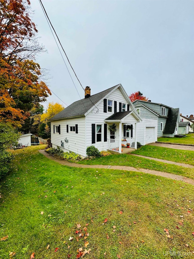 view of front of property with a garage, a front lawn, and covered porch