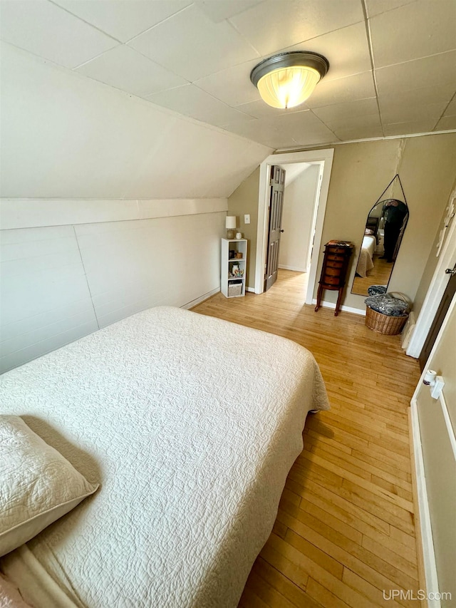 bedroom featuring lofted ceiling and wood-type flooring