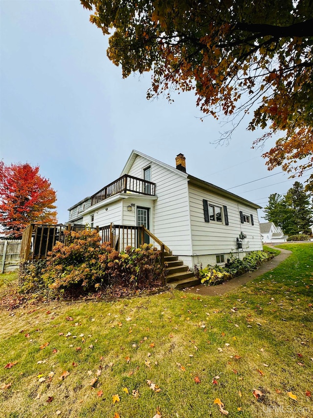 view of side of property with a deck and a lawn