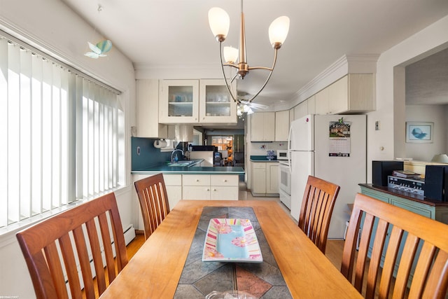 kitchen featuring white cabinetry, an inviting chandelier, pendant lighting, and white appliances