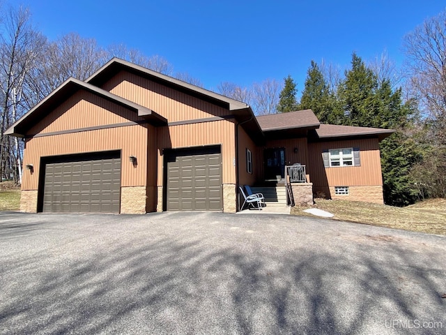 single story home with an attached garage and aphalt driveway