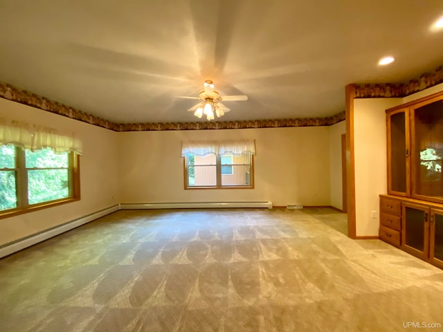 carpeted spare room featuring ceiling fan, a healthy amount of sunlight, and a baseboard radiator