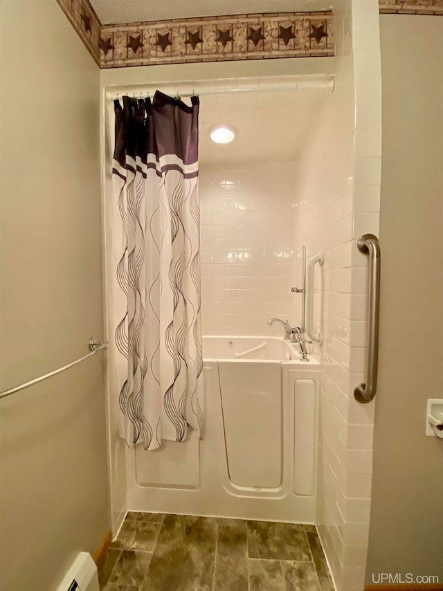 bathroom featuring a bath and a baseboard heating unit