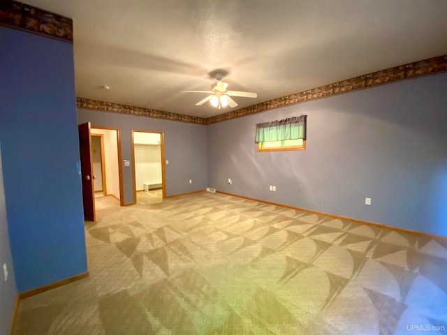 carpeted spare room featuring ceiling fan