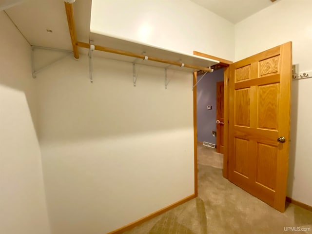 walk in closet featuring light carpet