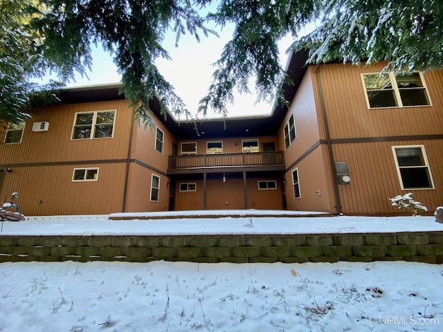 737 Grove St, Marquette, MI 49855 - snow covered rear of property with a balcony and a wall unit AC