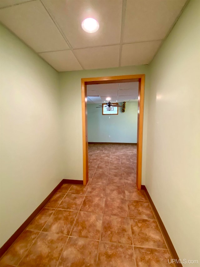 hall featuring a drop ceiling and tile patterned flooring