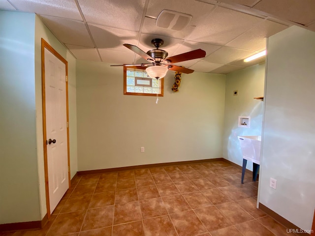 spare room featuring a paneled ceiling, tile patterned floors, and ceiling fan