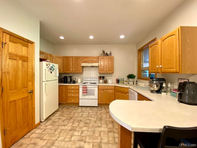 kitchen with kitchen peninsula, sink, and white appliances