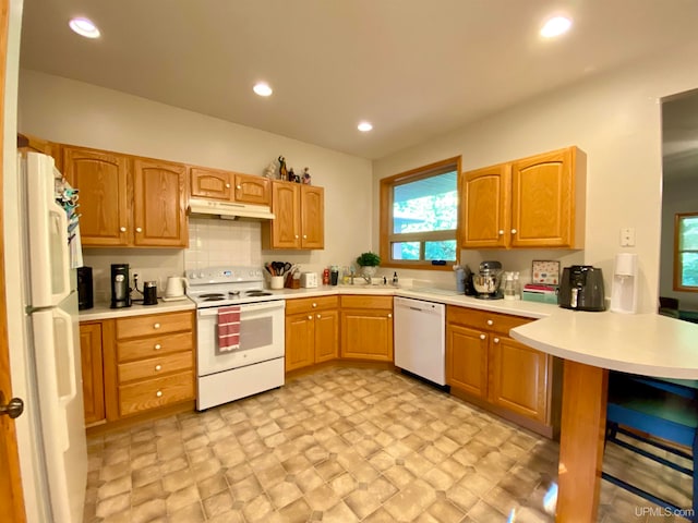 kitchen with white appliances, backsplash, sink, and kitchen peninsula