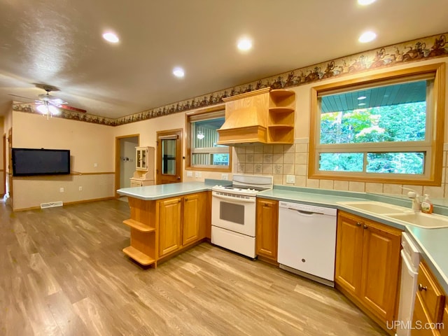 kitchen with kitchen peninsula, ceiling fan, light hardwood / wood-style floors, sink, and white appliances