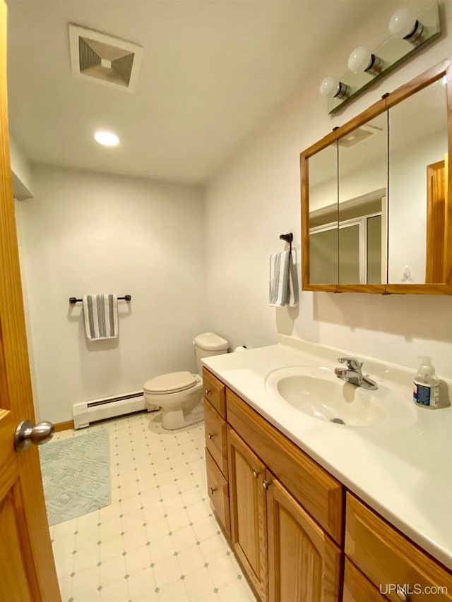 bathroom featuring toilet, baseboard heating, vanity, and a shower with door