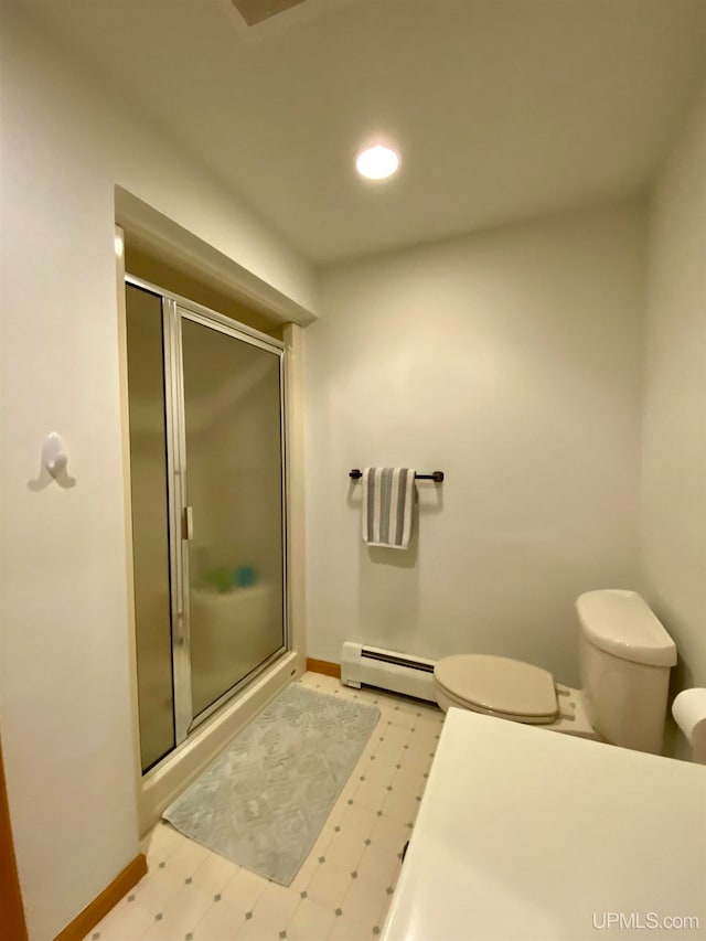 bathroom featuring a shower with door, toilet, and baseboard heating