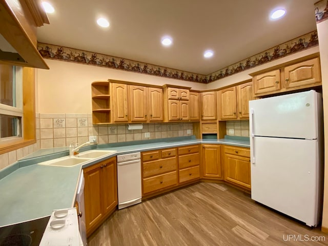 kitchen featuring sink, light hardwood / wood-style flooring, white appliances, and tasteful backsplash