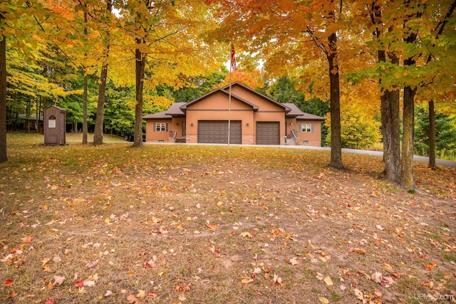 view of front facade with a storage unit and a garage