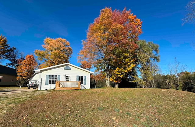 view of front of property with a deck and a front yard