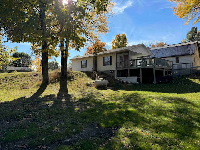 rear view of house featuring a yard and a deck