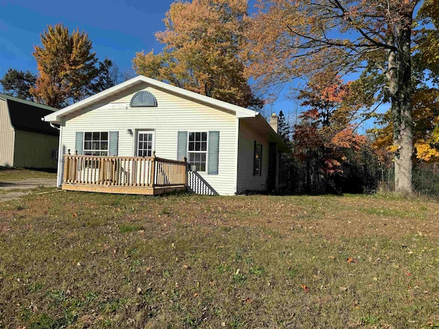 view of front of house with a deck and a front lawn