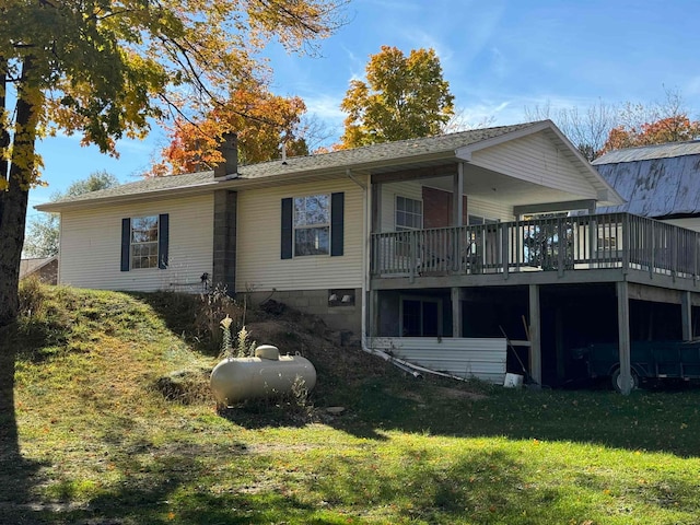 rear view of house featuring a lawn and a wooden deck