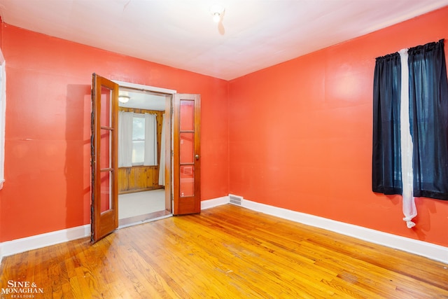 unfurnished room with wood-type flooring and vaulted ceiling