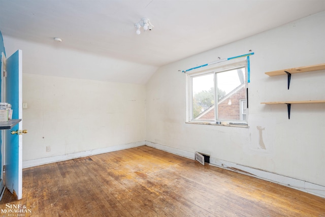 interior space featuring hardwood / wood-style flooring and vaulted ceiling