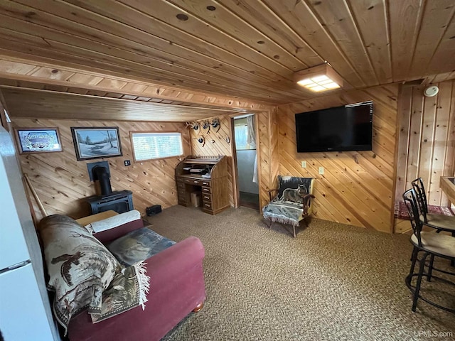 living room featuring wood ceiling, wood walls, and a wood stove