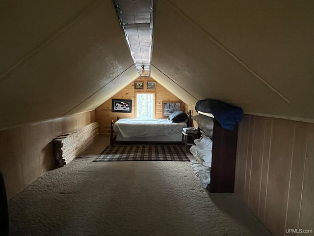 carpeted bedroom with lofted ceiling and wood walls