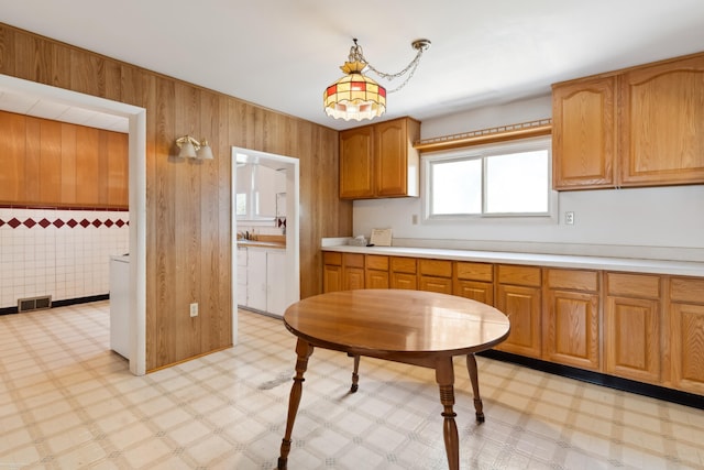 kitchen featuring wooden walls and pendant lighting