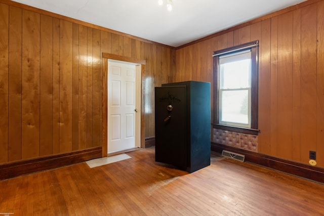 empty room featuring hardwood / wood-style flooring and wood walls