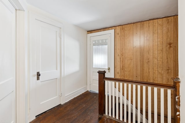 hall featuring wooden walls and dark hardwood / wood-style floors