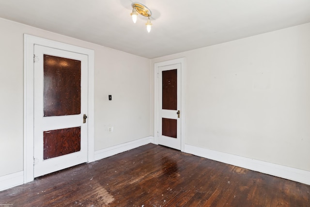 unfurnished room with dark wood-type flooring