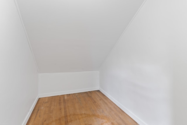 additional living space featuring lofted ceiling and light hardwood / wood-style flooring