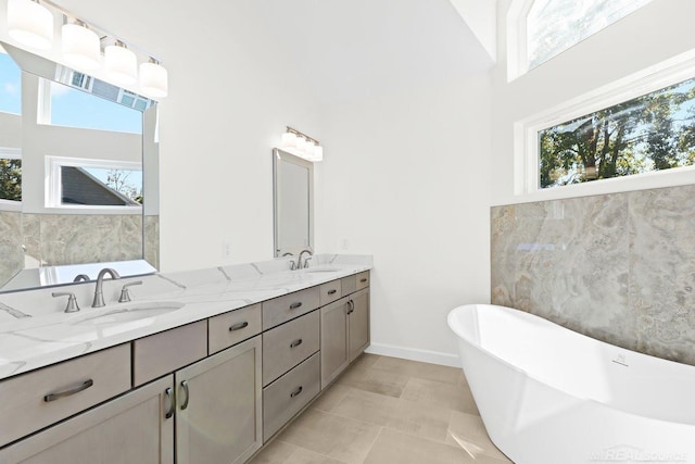 bathroom featuring tile walls, vanity, tile patterned floors, and a washtub