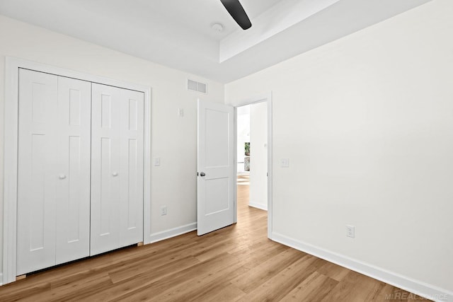 unfurnished bedroom featuring a closet, light wood-type flooring, and ceiling fan