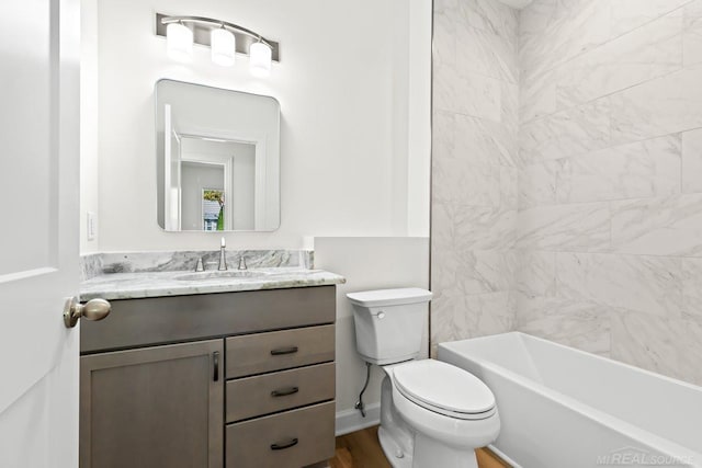 full bathroom with toilet, tiled shower / bath, vanity, and wood-type flooring