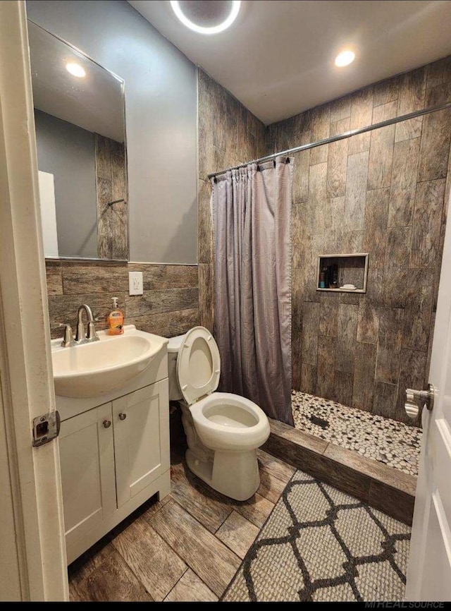 bathroom featuring vanity, toilet, tile walls, and a shower with shower curtain