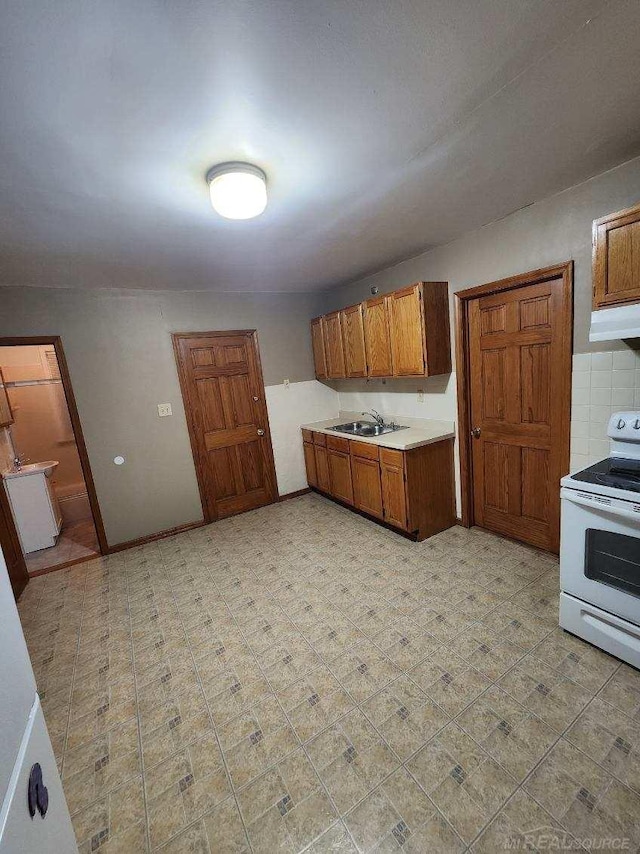 kitchen featuring sink, backsplash, and electric stove