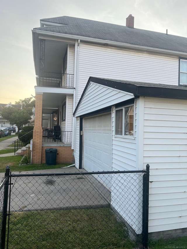 property exterior at dusk with a balcony and a lawn