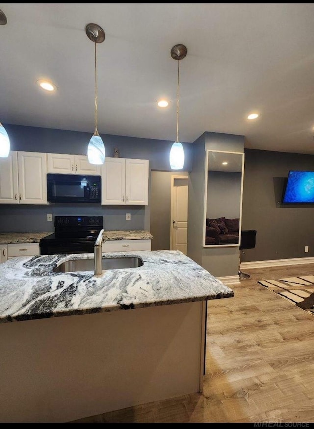 kitchen featuring white cabinetry, black appliances, and decorative light fixtures