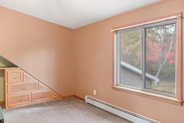 carpeted spare room featuring baseboard heating