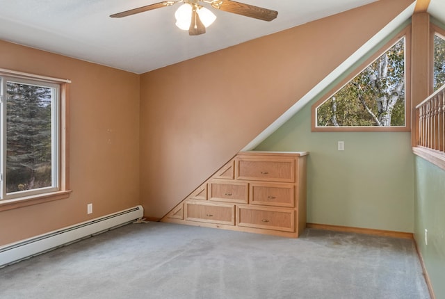 bonus room with a baseboard radiator, light colored carpet, and ceiling fan