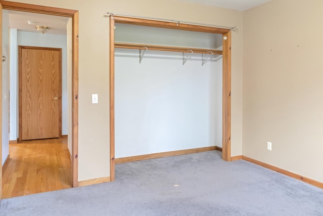 unfurnished bedroom featuring a closet and light wood-type flooring