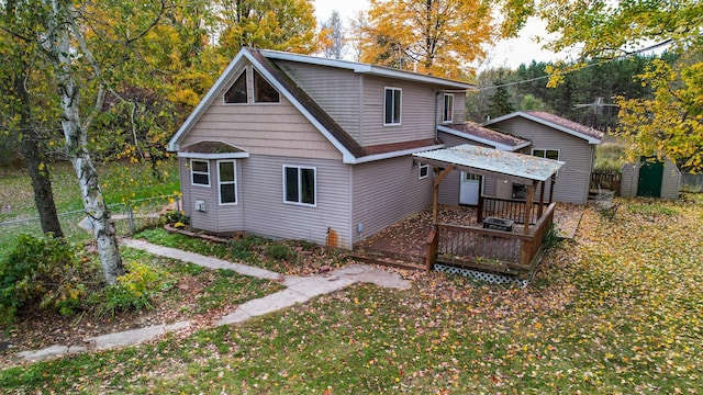 rear view of house featuring a storage unit and a wooden deck