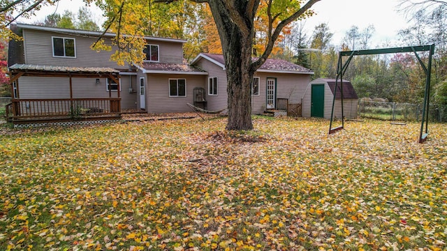 back of house with a shed and a deck