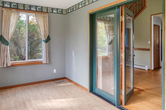 spare room featuring light hardwood / wood-style floors and a baseboard heating unit