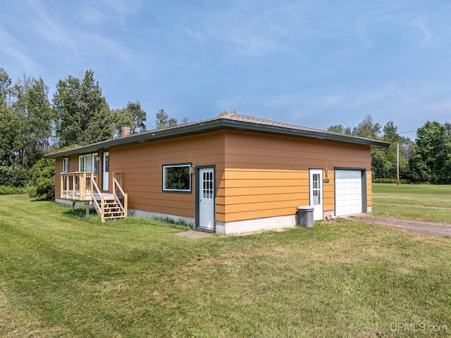 view of side of property with a garage and a lawn