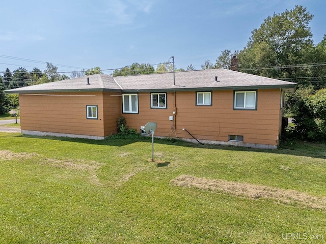 rear view of house featuring a lawn