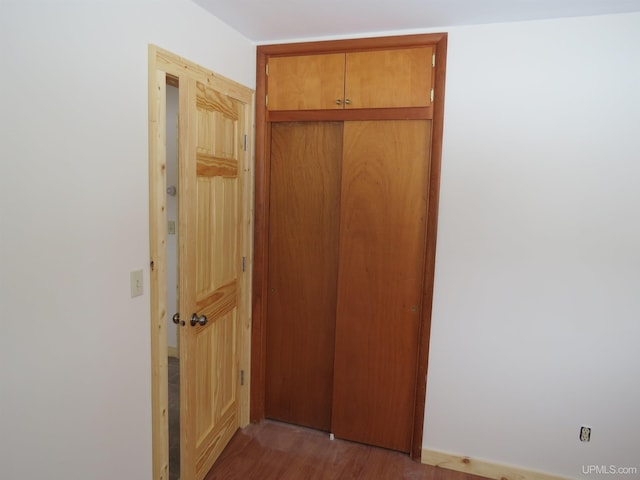 hallway with hardwood / wood-style floors