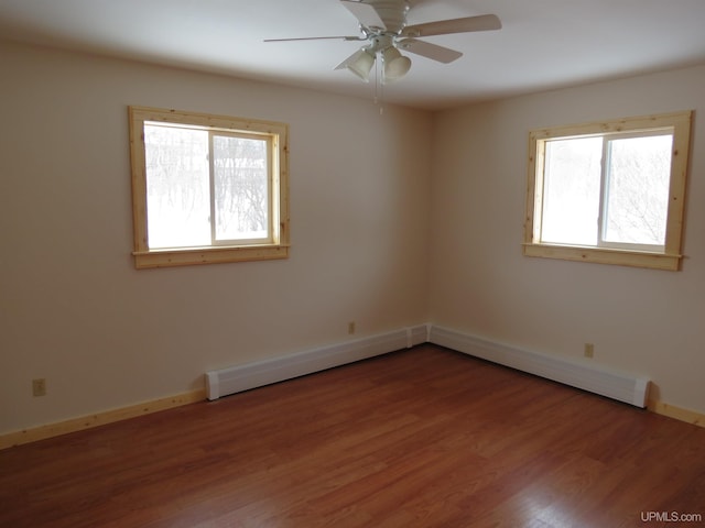 empty room with ceiling fan, wood-type flooring, and plenty of natural light