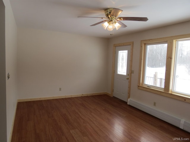 interior space with dark wood-type flooring, a baseboard heating unit, and ceiling fan